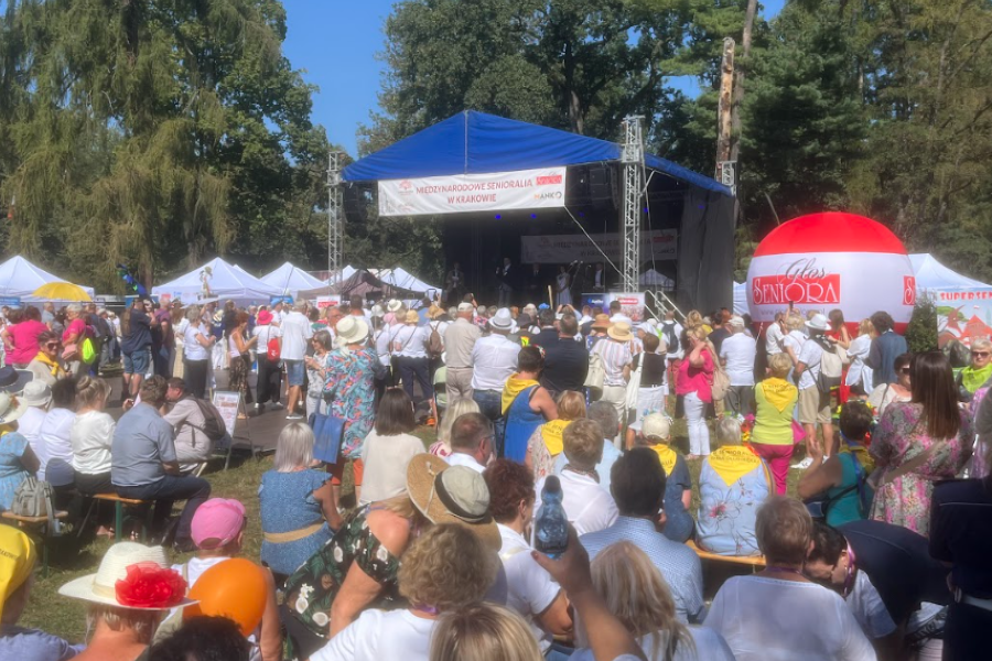 Scena, na której odbywały się główne wydarzenia i uczestnicy wydarzenia siedzący na ławeczkach. 