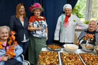 Pożegnanie lata 19.09.2024 Pani Dyrektor, terapeuta w stroju kucharza i troje mieszkańców przy stole z szaszłykami.
