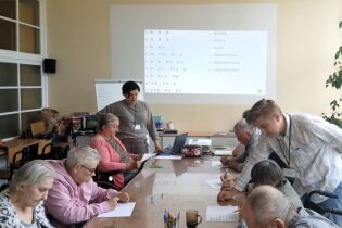 Procesy poznawcze 23.09.2024 Mieszkańcy siedzą przy długim stole, rozwiązują zadania.