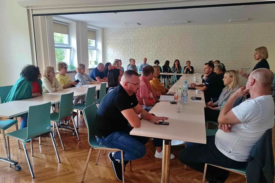 kilkanaście osób siedzących przy stołach 