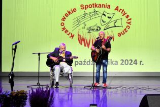 Przegląd Gaudium 23.10.2024 Na scenie mieszkaniec na wózku inwalidzkim gra na gitarze razem z terapeutą.