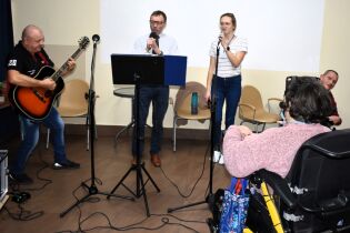 Muzykoterapia 25.11.2024 Dwoje mieszkańców słucha, Pan Dyrektor i dwoje terapeutów śpiewają piosenki.