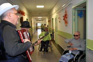 Kameralne koncerty 28.11.2024 Akordeonista gra, w tle kilku zasłuchanych mieszkańców.