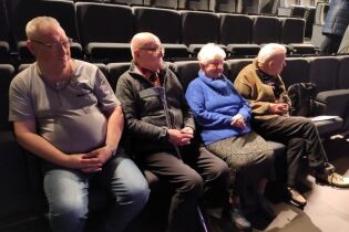Koncert w CSW Solvay 11.12.2024 Czworo mieszkańców siedzi w fotelach w sali widowiskowej.