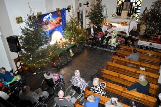 Koncert 27.12.2024 Trzej muzycy , szopka i mieszkańcy zgromadzeni w kaplicy.