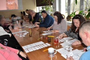 Procesy poznawcze 24.02.2025 Kilkunastu mieszkańców siedzi przy długim stole, przed sobą mają kartki z zadaniami.