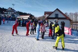 Grupa dzieci na nartach oczekuje przy wyciągu narciarskim