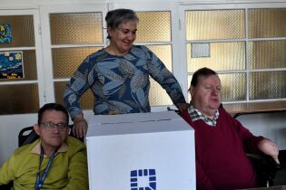 Wybory 06.03.2025 Troje mieszkańców z urną wyborczą.