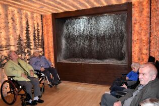 Grota solna 01.04.2025 Kilkoro mieszkańców siedzi w sali wyłożonej bryłkami soli