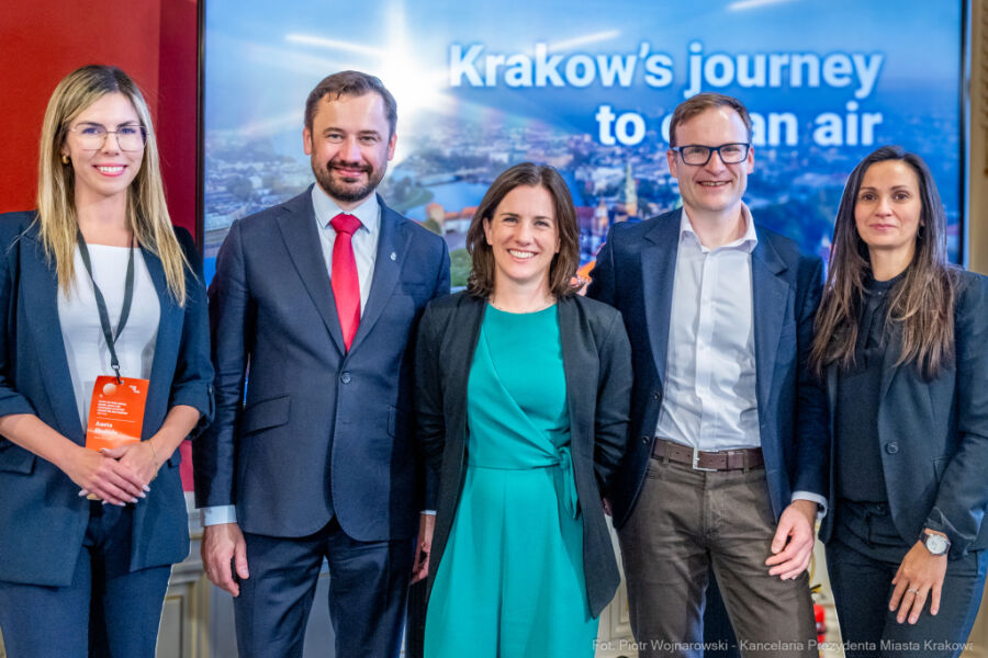 Spotkanie Prezydenta Krakowa Aleksandra Miszalskiego z przedstawicielami Clear Air Fund w Pałacu Potockich 19 maja 2025 r. Na fotografii widać 3 kobiety i 2 mężczyzn którzy pozują ustawieni w szeregu na tle telebimu z prezentacją. Drugi od lewej stoi Prezydent Krakowa.