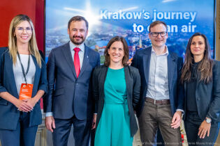 Clean Air Fund z wizytą w Krakowie – miasto w centrum działań na rzecz czystego powietrza Spotkanie Prezydenta Krakowa Aleksandra Miszalskiego z przedstawicielami Clear Air Fund w Pałacu Potockich 19 maja 2025 r. Na fotografii widać 3 kobiety i 2 mężczyzn którzy pozują ustawieni w szeregu na tle telebimu z prezentacją. Drugi od lewej stoi Prezydent Krakowa.