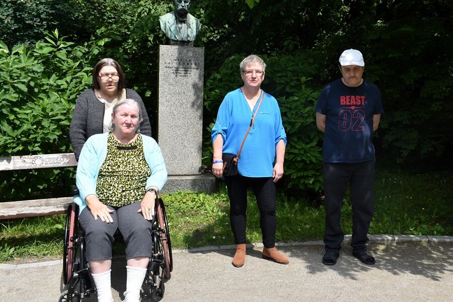 Czworo mieszkańców na tle popiersia Mariana Raciborskiego