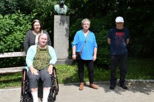 Czworo mieszkańców na tle popiersia Mariana Raciborskiego