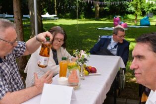 Piknik 13.06.2025 Czworo mieszkańców siedzi przy stole.