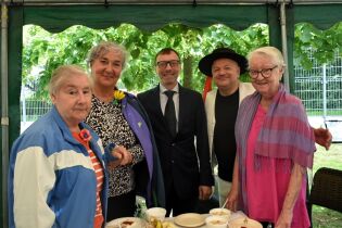 Piknik 17.06.2025 Trzy Mieszkanki, Pan Dyrektor i terapeuta pozują do zdjęcia.