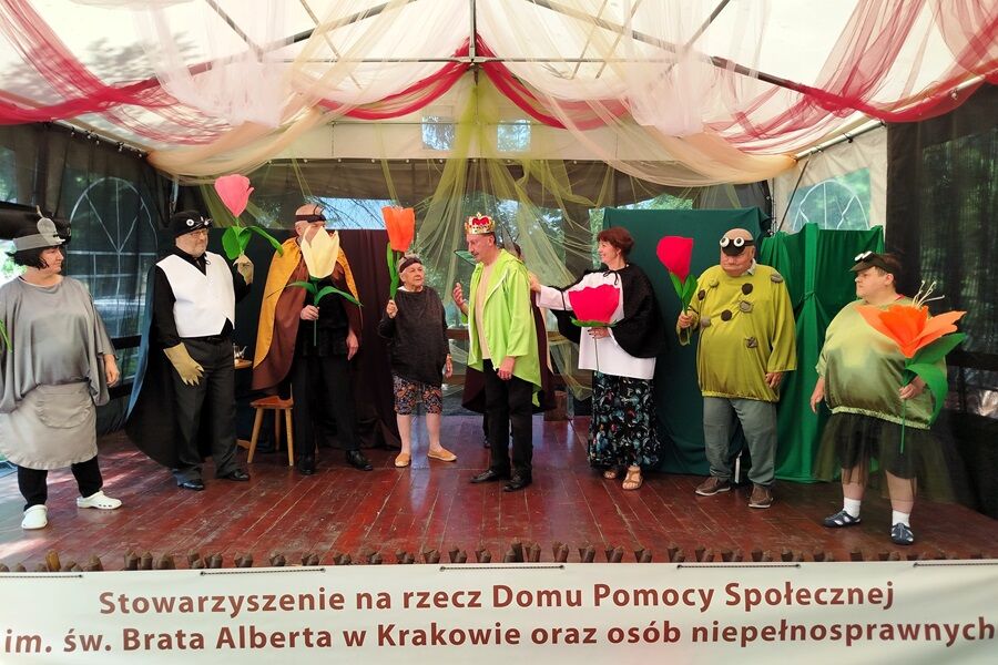 Grupa teatralna w kolorowych strojach.