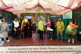 Grupa teatralna w kolorowych strojach.