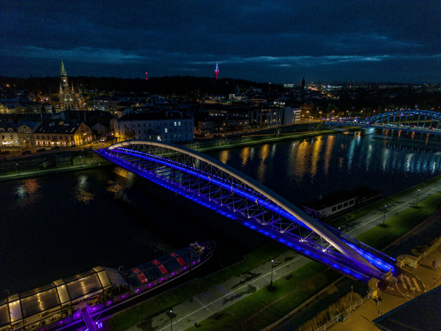 kładka Bernatka podświetlona po zmierzchu na niebiesko. Ujęcie z lotu ptaka. 