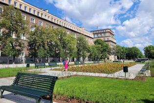 Grafika przedstawia zdjęcie wiosennej Alei Róż w Nowej Hucie.