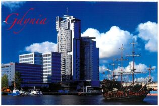 Pozdrowienie z Gdyni 25.08.2025 "Panorama Gdyni – na pierwszym planie port z widocznym żaglowcem stylizowanym na dawny statek piracki, po lewej stronie nowoczesne budynki biurowe i hotelowe, a w tle wysoki wieżowiec Sea Towers.