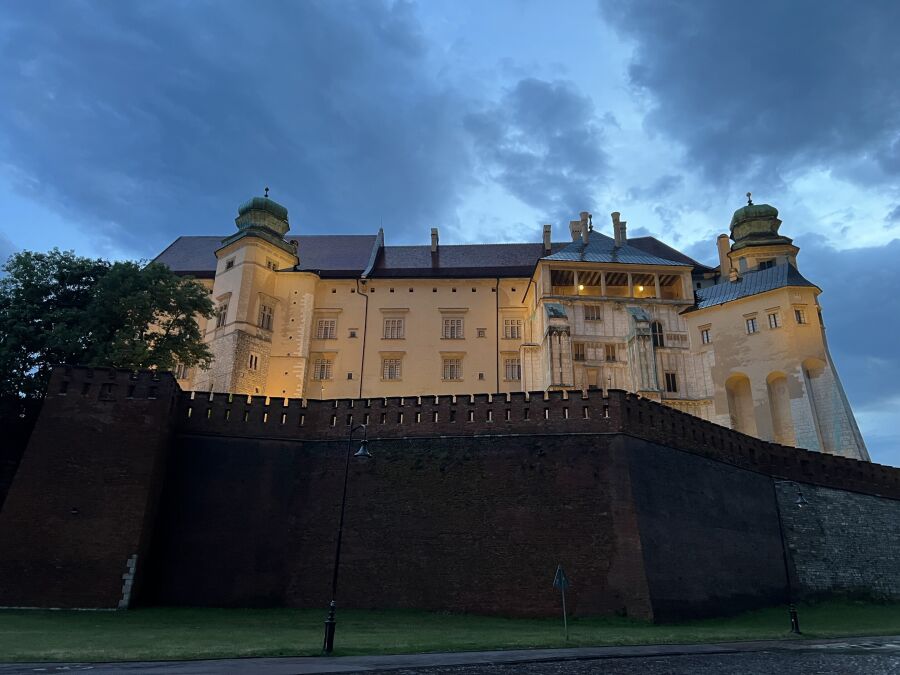 Zdjęcie przedstawia widok Wzgórza Wawelskiego na tle zachmurzonego, błękitno-szarego nieba.