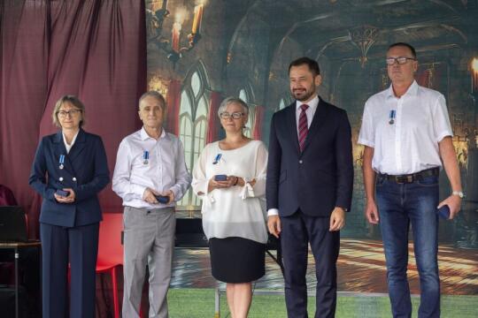 pięć osób stojących na scenie. w Tle scenografia imitująca średniowieczny zamek