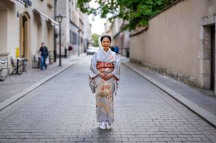Japonka w tradycyjnym kimono stoi na środku starej uliczki w Krakowie