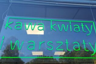 zdjęcie przedstawia szyld Kawiarni – nawiązanie szyldu do neonów w Nowej Hucie