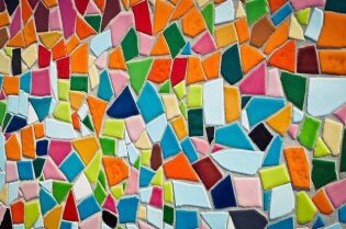 Grafika przedstawia wiele różnokolorowych szkiełek, ułożonych obok siebie.