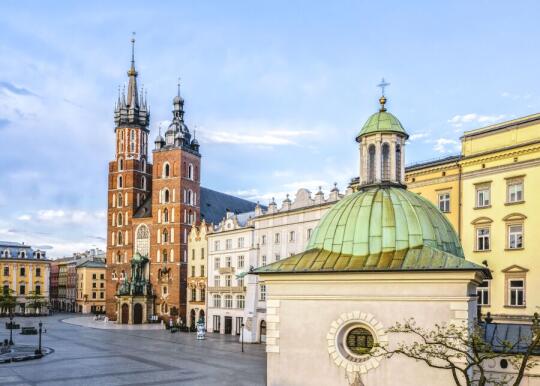 Rynek Główny w Krakowie. Na pierwszym planie po prawej kościół św. Wojciecha. W tle sylwetka Kościoła Mariackiego.   