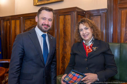 Wizyta nowej Ambasador Brytyjskiej JE Melindy Simmons u Prezydenta Miasta Krakowa Aleksandra Miszalskiego 5 grudnia 2026 r. na fotografii oboje stoją na pierwszym planie w tle gabinet. 