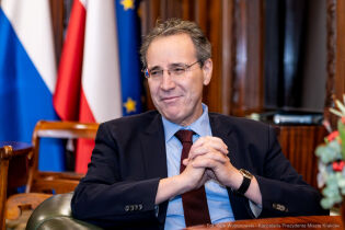 Ambasador Niemiec JE Miguel Berger z wizytą u Prezydenta Krakowa 9.12.2025. Zdjęcie portretowe dyplomaty na fotelu w gabinecie Prezydenta. Ambasador jest uśmiechnięty. 