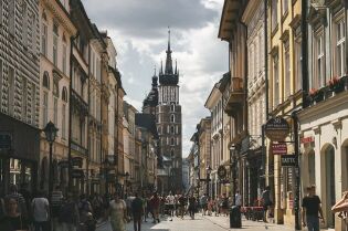 Grafika przedstawia ulicę Floriańską pełną turystów z widokiem na Kościół Mariacki