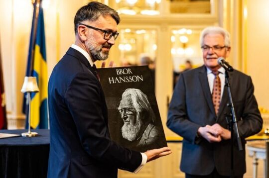 Uroczystość ponownego otwarcia konsulatu Szwecji. Wręczenie tablicy z podobizną filantropa Brora Hanssona. Na zdjęciu nowy Konsul Szwecji trzyma kamienną tablicę z podobizną mężczyzny.