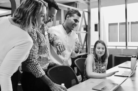 Grupa stojących osób. Zdjęcie czarno białe. 