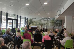 Na zdjęciu mieszkańcy słuchają fortepianowego koncertu muzyki filmowej w wykonaniu Piotra Karola.