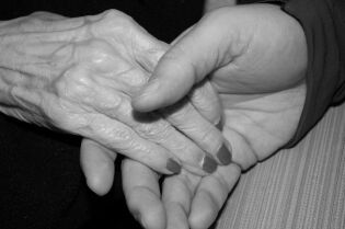 Grafika przedstawia dwie dłonie. Jedna dłoń spoczywa w drugiej.