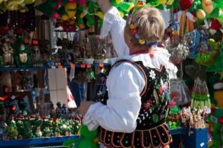 Grafika przedstawia kobietę w stroju krakowskim.