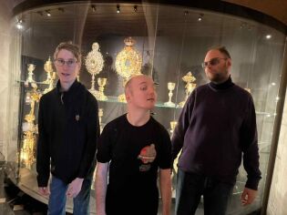 Uczestnicy na tle paramentów liturgicznych