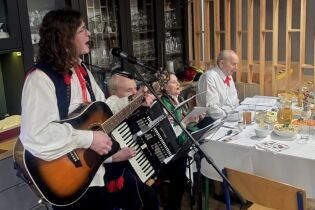 Uczestnicy spotkania przy stołach wigilijnych.