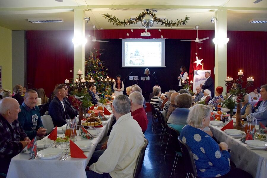 Mieszkańcy przy stole wigilijnym w sali terapii zajęciowej