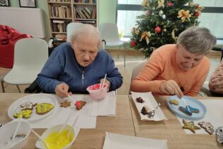 Na zdjęciu Mieszkanki dekorują pierniki z zaangażowaniem.