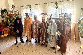 grupa osób w kostiumach odgrywa Jasełka 