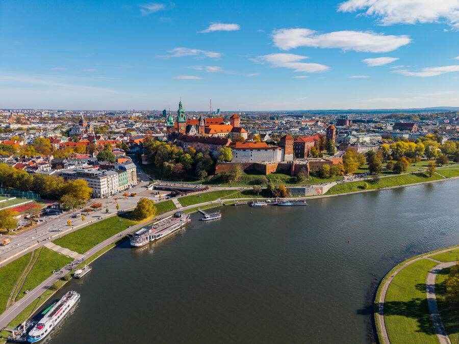 Zdjęcie wykonane z drona. Widok na zakole Wisły i zamek na Wawelu oraz zazielenione bulwary nad rzeką                     