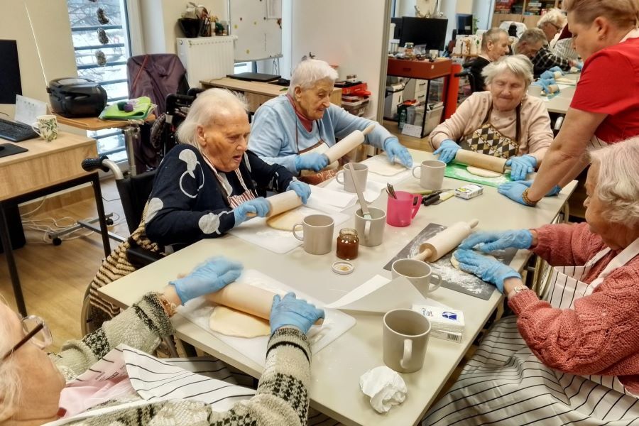 Na zdjęciu Mieszkanki wałkują ciasto podczas zajęć kulinarnych – rogaliki.