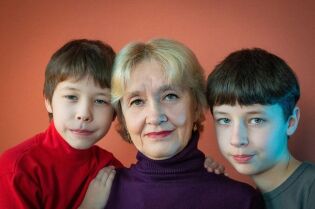 Grafika przedstawia postać starszej kobiety w otoczeniu dwóch wnuków.