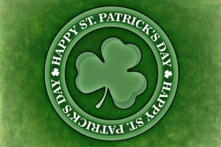 Grafika na której na zielonym tle imitującym tkaninę jest okrągła przypinka z trójlistną koniczyną w środku a w otoku napis Happy St. Patrick's Day