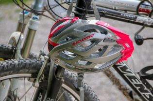 Grafika przedstawia fragment roweru oraz kask rowerowy.