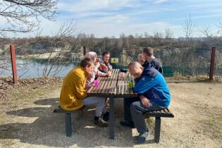 Uczestnicy wspólnie siedzą przy stole i podziwiają widoki