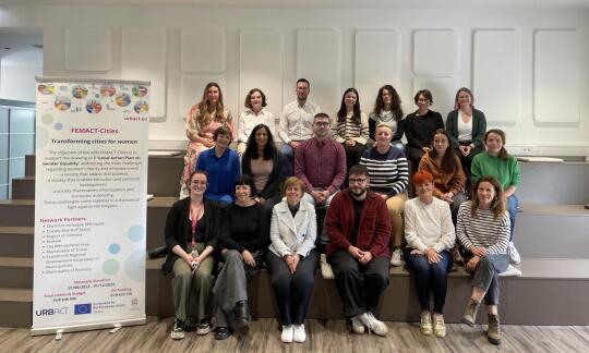 Zdjęcie grupowe członków sieci planowania działań FEMACT-Cities obok banera projektu dotyczącego przekształcania miast z myślą o kobietach.
